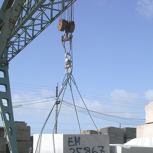 A large stone block is rigged with steel cable and a load cell.